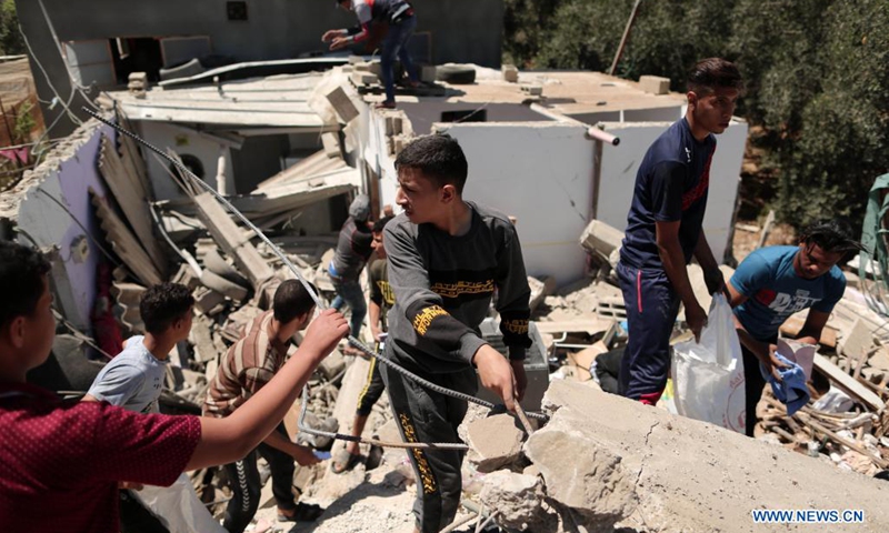 Palestinians inspect a destroyed house after an Israeli airstrike in Bani Suhaila, east of the southern Gaza Strip city of Khan Younis, May 19, 2021. Five Palestinians, including a local journalist, were killed on Wednesday in a fresh round of Israeli airstrikes on the Gaza Strip that have been going on for 10 days, medics said.(Photo: Xinhua)
