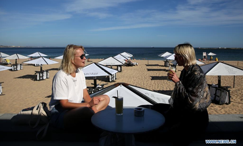 People enjoy the sun at the beach in Cascais, Portugal on May 19, 2021. British vacationers began arriving in large numbers in Portugal after governments of the two countries eased their COVID-19 pandemic travel restrictions.(Photo: Xinhua)