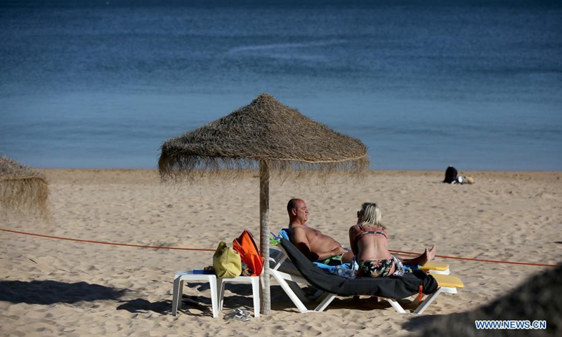 People enjoy the sun at the beach in Cascais, Portugal on May 19, 2021. British vacationers began arriving in large numbers in Portugal after governments of the two countries eased their COVID-19 pandemic travel restrictions.(Photo: Xinhua)