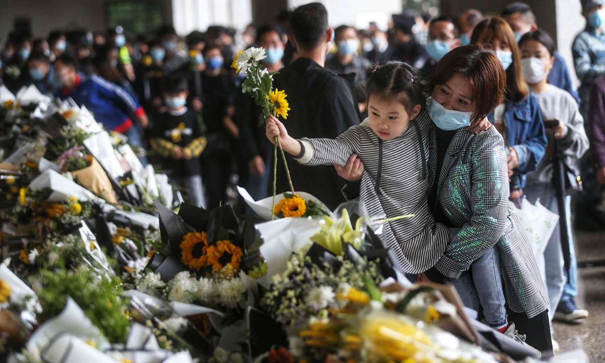 A mother brings her child to the memorial hall of Mingyangshan Funeral Home to lay flowers in tribute. Photo: Cui Meng/GT