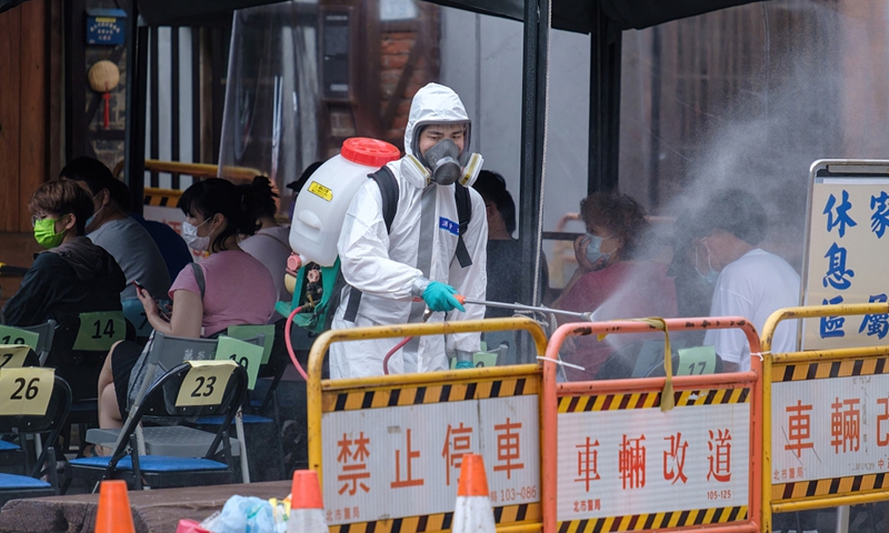 Military personnel sprays disinfectants while residents are waiting to get tested for COVID-19 in Wanhua on May 21. Photo: VCG