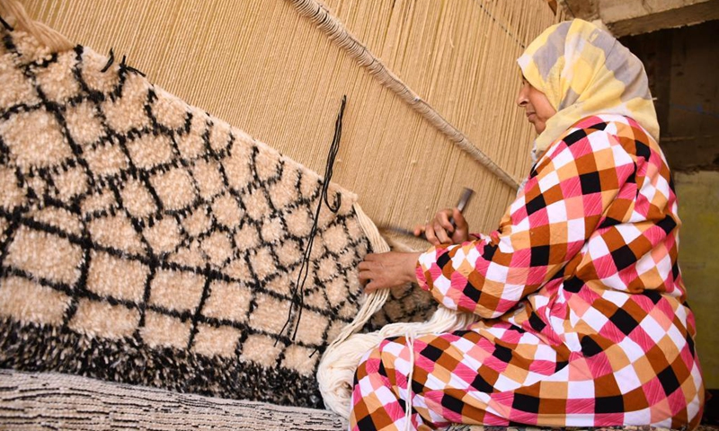 A woman weaves a traditional carpet in Tiflet, Morocco, on May 23, 2021. The Tiflet region is famous for berber-style handwoven carpets. (Photo by Chadi/Xinhua)