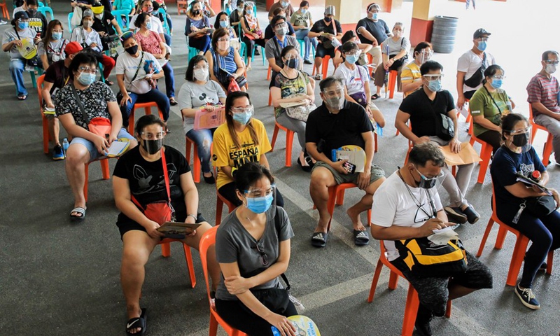 Residents wearing protective masks wait to receive Sinovac vaccines at a vaccination site in Manila, the Philippines on March 31, 2021.(Photo: Xinhua)
