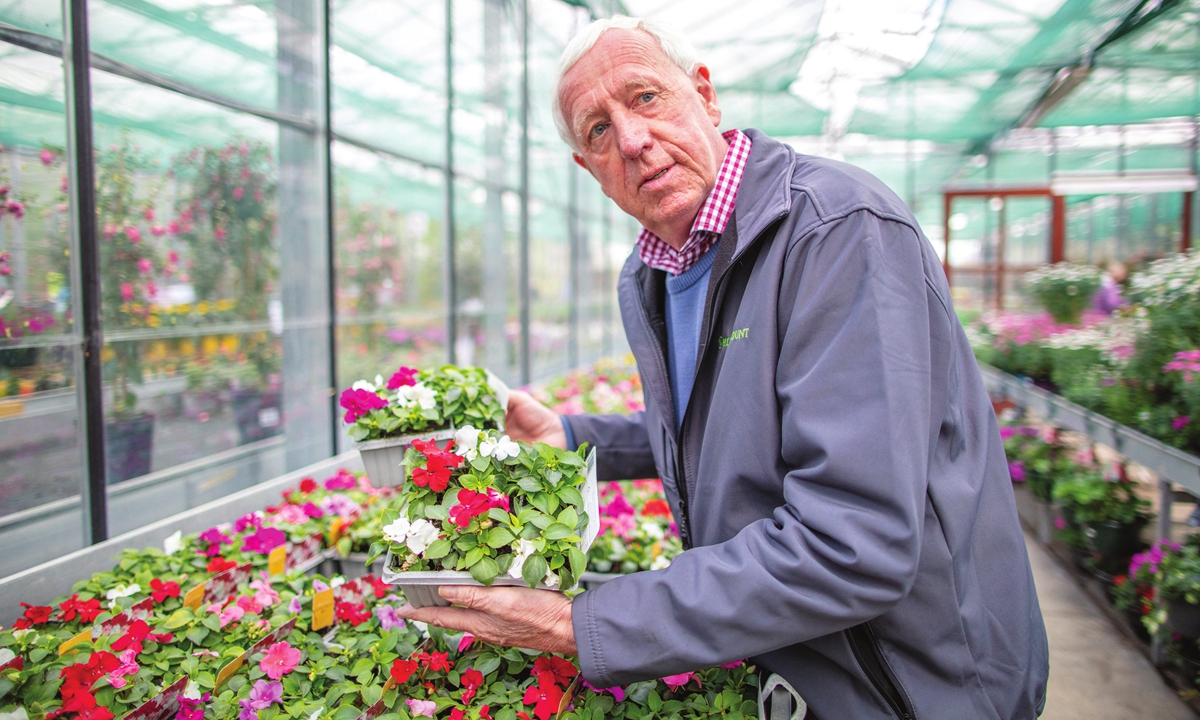 Owner, Robin Mercer, poses amongst flowering plants in a greenhouse at Hillmount Garden Centre in East Belfast, the UK, on Wednesday. Photo: AFP
