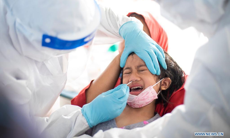 A medical worker takes a swab sample from a girl for COVID-19 test in Subang Jaya, Selangor, Malaysia, May 23, 2021. Malaysia on Sunday reported 6,976 new COVID-19 infections in the highest daily spike since the outbreak, bringing the national total to 512,091, the health ministry said.(Photo: Xinhua)