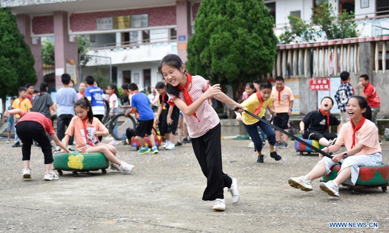 Students play games with used tires at playtime at Xianling Primary School, Penghu Township, Yongchun County of southeast China's Fujian Province, May 25, 2021. The primary school has tried to combine used tires with sports activities and created dozens of rubber ring games since 2018. These games, which turned waste into useful tools, have become a distinguishing feature of the school.(Photo: Xinhua)