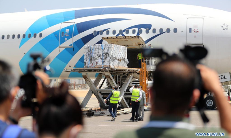 Airport staff members unload the first batch of Chinese Sinovac vaccine raw materials from a plane at the Cairo International Airport in Cairo, Egypt, May 21, 2021. Egypt has received the first batch of the raw materials to manufacture China's Sinovac vaccine, said the Chinese embassy in Egypt on Sunday. Along with the Sinovac raw materials, a new shipment of China's Sinopharm COVID-19 vaccines also arrived at the Cairo International Airport on Friday, according to a Chinese embassy's statement.(Photo: Xinhua)