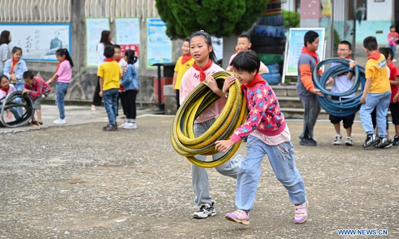 Students play games with used tires at playtime at Xianling Primary School, Penghu Township, Yongchun County of southeast China's Fujian Province, May 25, 2021. The primary school has tried to combine used tires with sports activities and created dozens of rubber ring games since 2018. These games, which turned waste into useful tools, have become a distinguishing feature of the school.(Photo: Xinhua)