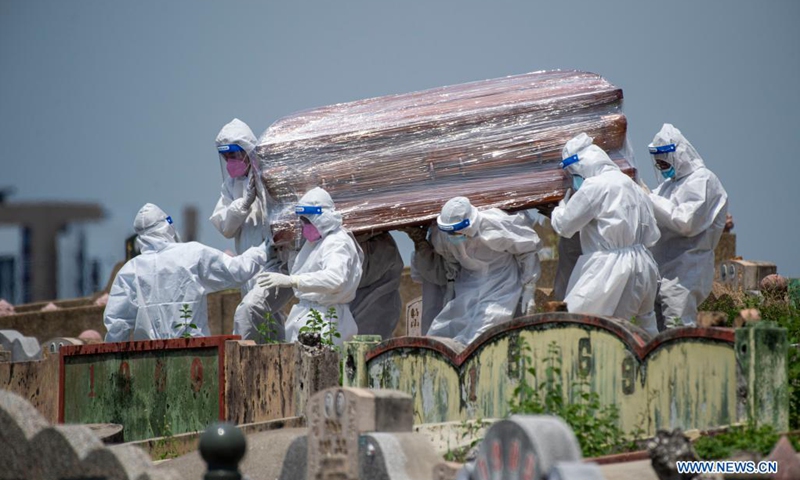 People in protective suits carry a coffin of a COVID-19 victim at a graveyard in Klang, Selangor, Malaysia, May 23, 2021. Malaysia on Sunday reported 6,976 new COVID-19 infections in the highest daily spike since the outbreak, bringing the national total to 512,091, the health ministry said.(Photo: Xinhua)