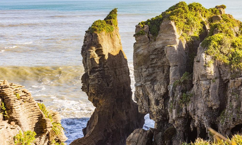 Photo taken on May 25, 2021 shows a view of the Pancake Rocks in Punakaiki on the West Coast of the South Island, New Zealand. The Pancake Rocks were formed from minute fragments of dead marine creatures and plants landed on the seabed. (Photo by Zhang Jianyong/Xinhua)

