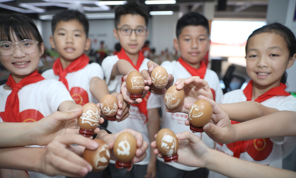 Pupils at a primary school in Dongyang, East China's Zhejiang Province, display egg sculptures on Wednesday, after a carving course offered by Zhejiang Guangsha Vocational and Technical University of Construction. Students are celebrating the upcoming 100th anniversary of the founding of the Communist Party of China by engraving Party emblems and other patterns on eggs. Photo: IC