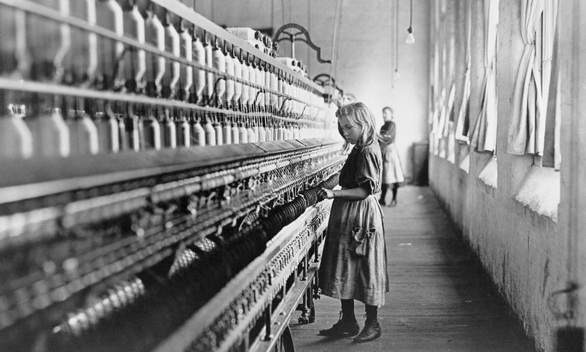 A young girl tends the spinning machine at a cotton mill in North Carolina. File photo: VCG