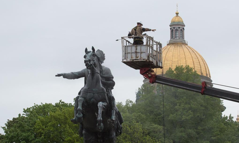A worker cleans the bronze statue of Peter the Great, the founder of St. Petersburg, in preparation for the celebration of the 318th anniversary of the founding of the city, in St. Petersburg, Russia, on May 26, 2021. (Photo by Irina Motina/Xinhua)

