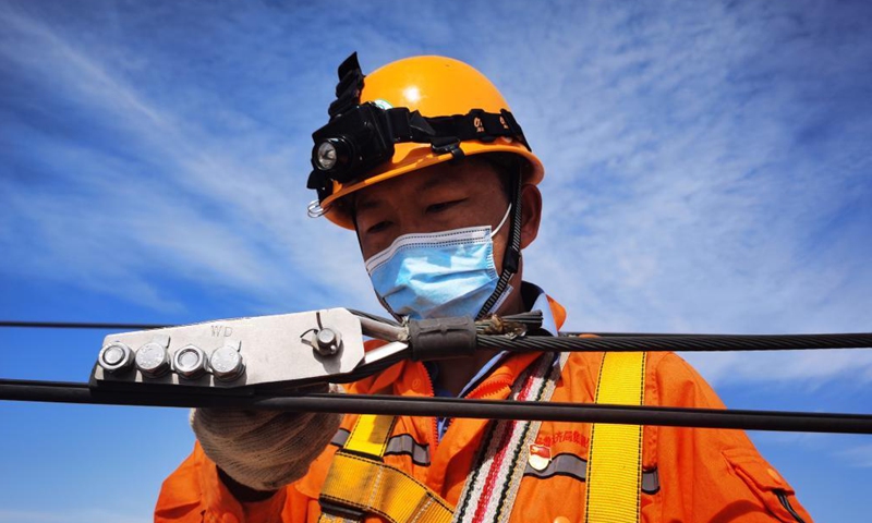 A railway staff member overhauls the catenary equipment of Karamay-Tacheng Railway in northwest China's Xinjiang Uygur Autonomous Region, May 21, 2021. (Photo by Duan Yanan/Xinhua)