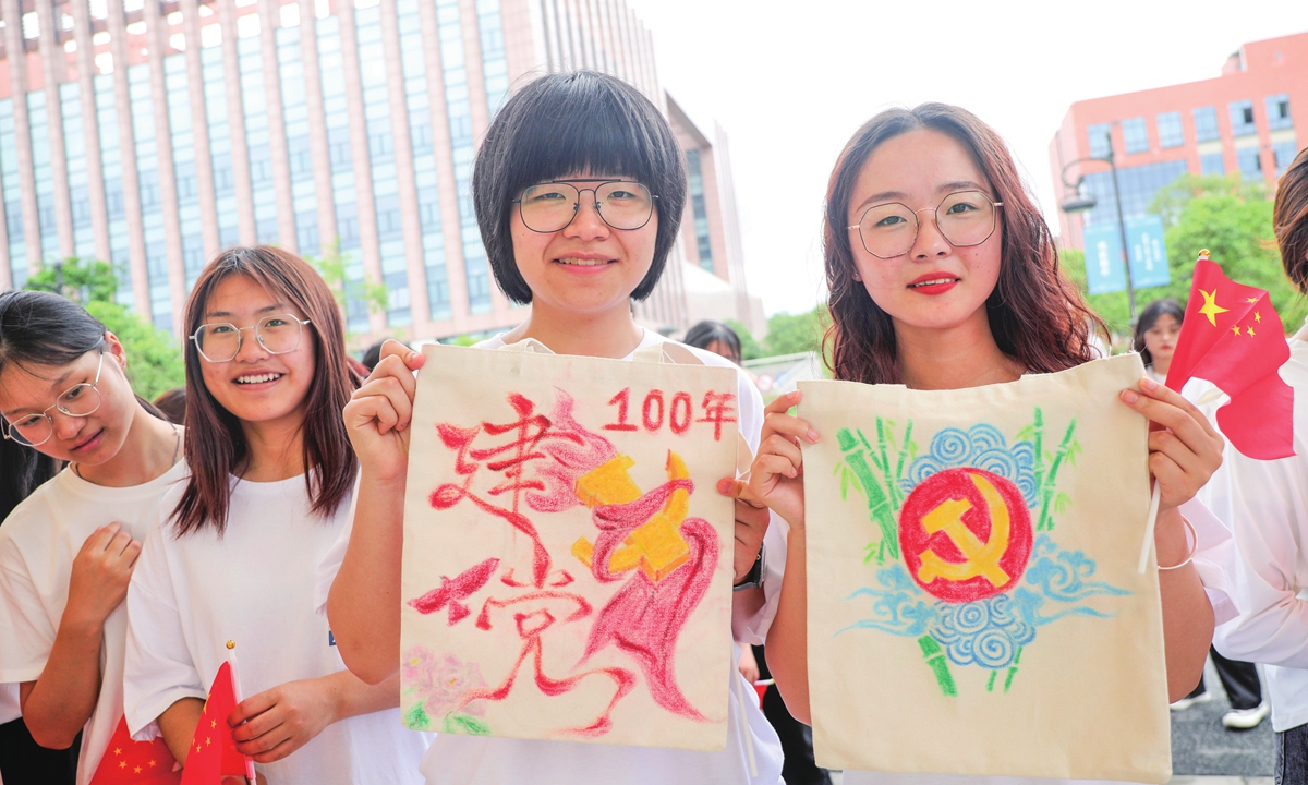 Two college students present the handcrafted bags featuring CPC elements in Hangzhou,  Zhejiang Province on May 16.
Photo: IC