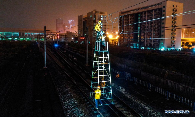 Aerial photo taken on May 26, 2021 shows railway staff members replacing the hanging strings of the overhead contact system at a railroad section in Nanning, south China's Guangxi Zhuang Autonomous Region. (Photo by Duan Yanan/Xinhua)