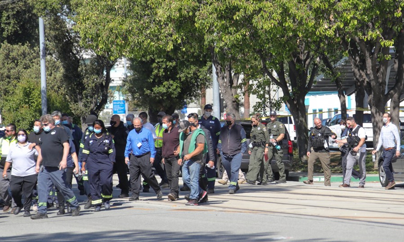Police escort people to a reunification center for VTA employees and families near the scene of a mass shooting in San Jose, California, the United States, on May 26, 2021.(Photo: Xinhua)