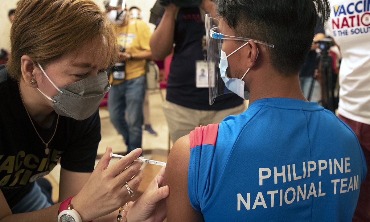 An athlete is given a shot of China's Sinovac COVID-19 vaccine in Manila, Philippines. Several Filipino athletes and delegates were vaccinated on Friday in preparation for the Tokyo Olympics and Southeast Asian Games. Photo: VCG