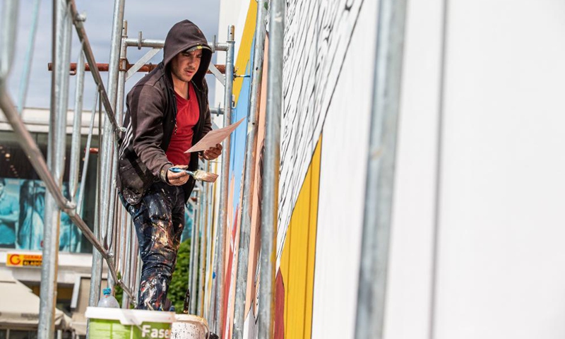 An artist paints a mural on the wall of a building in Vukovar, Croatia, May 27, 2021. Street art festival VukovART, which features murals created by world-famous artists on the walls and sidewalks, is held in Vukovar for the fifth year in a row. Photo: Xinhua
