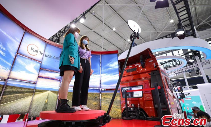 Two girls experience 360-degree panoramas?on?road trips at the 2021 China International Big Data Expo, May 27, 2021. Photo: China News Service