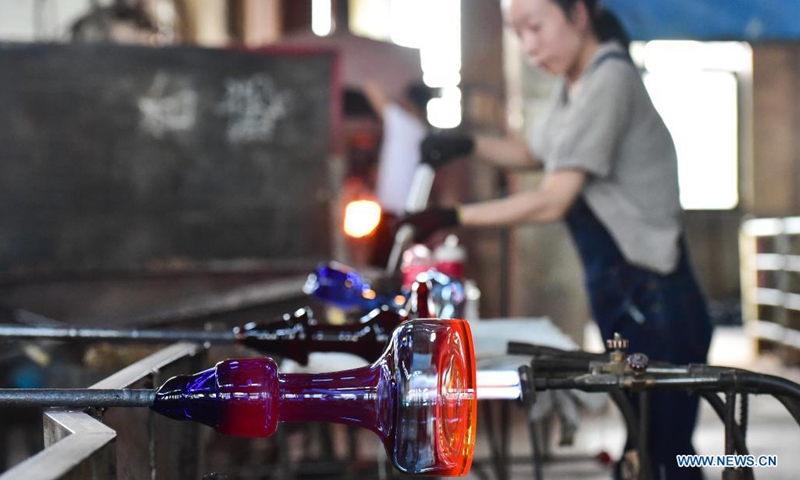 A worker makes glassware in Qixian County, north China's Shanxi Province, May 26, 2021. Glassware made in Qixian County has been exported to over 80 countries and regions.Photo:Xinhua