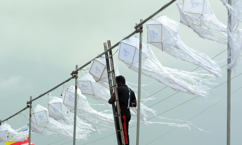 A man installs lantern decorations for the Vesak festival in Colombo, Sri Lanka, on May 26, 2021. The Vesak festival is one of the holiest festivals celebrated in Sri Lanka as it marks the birth, enlightenment and demise of Lord Buddha. Photo: Xinhua