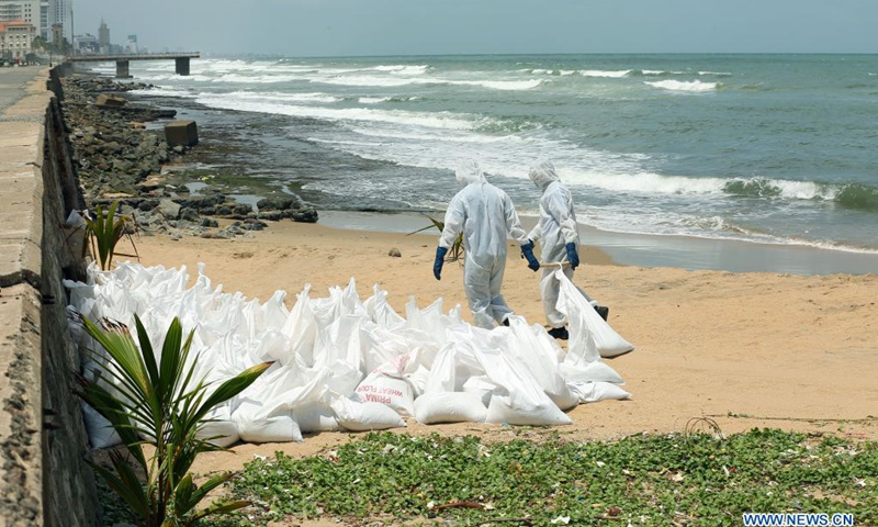 Sri Lankan security personnel load up a truck with debris from the X-Press Pearl ship in Colombo, Sri Lanka, on May 29, 2021. Sri Lankan Prime Minister Mahinda Rajapaksa on Saturday made an inspection visit to the coastal area in Uswetakeiyawa on the outskirts of capital Colombo which is affected by the debris washed up from the fire-ravaged container ship X-Press Pearl, the Prime Minister's Office said.(Photo: Xinhua)