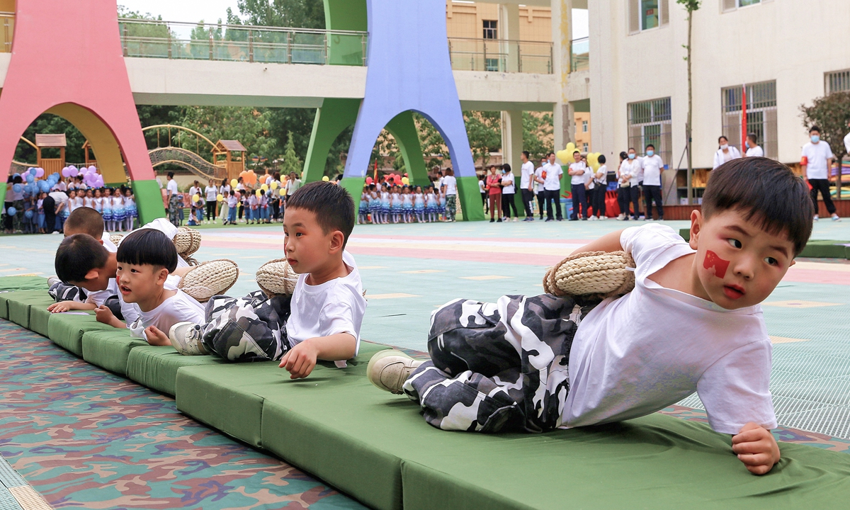 Boys bellycrawl during an activity to mark Children’s  Day at a kindergarten in Xiaxian, Shanxi. Photo: IC