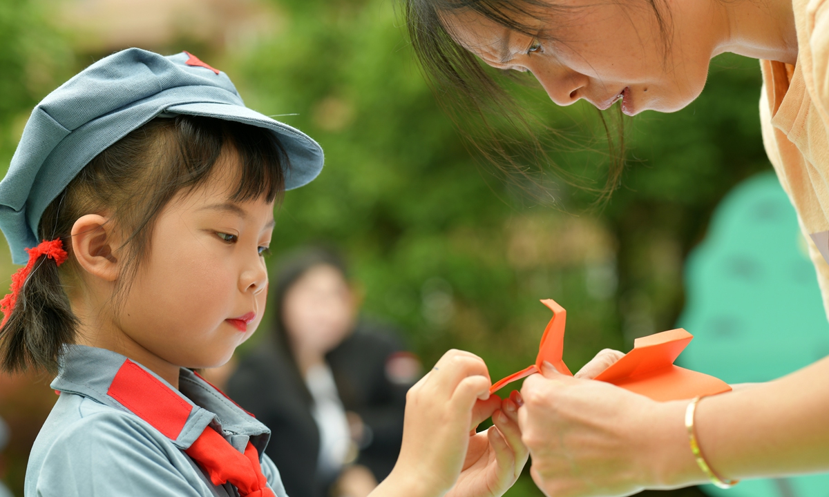 A girl in Red Army uniform takes part in an event to celebrate the Children's Day and the 100th anniversary of the founding of the Communist Party of China. Photo: IC