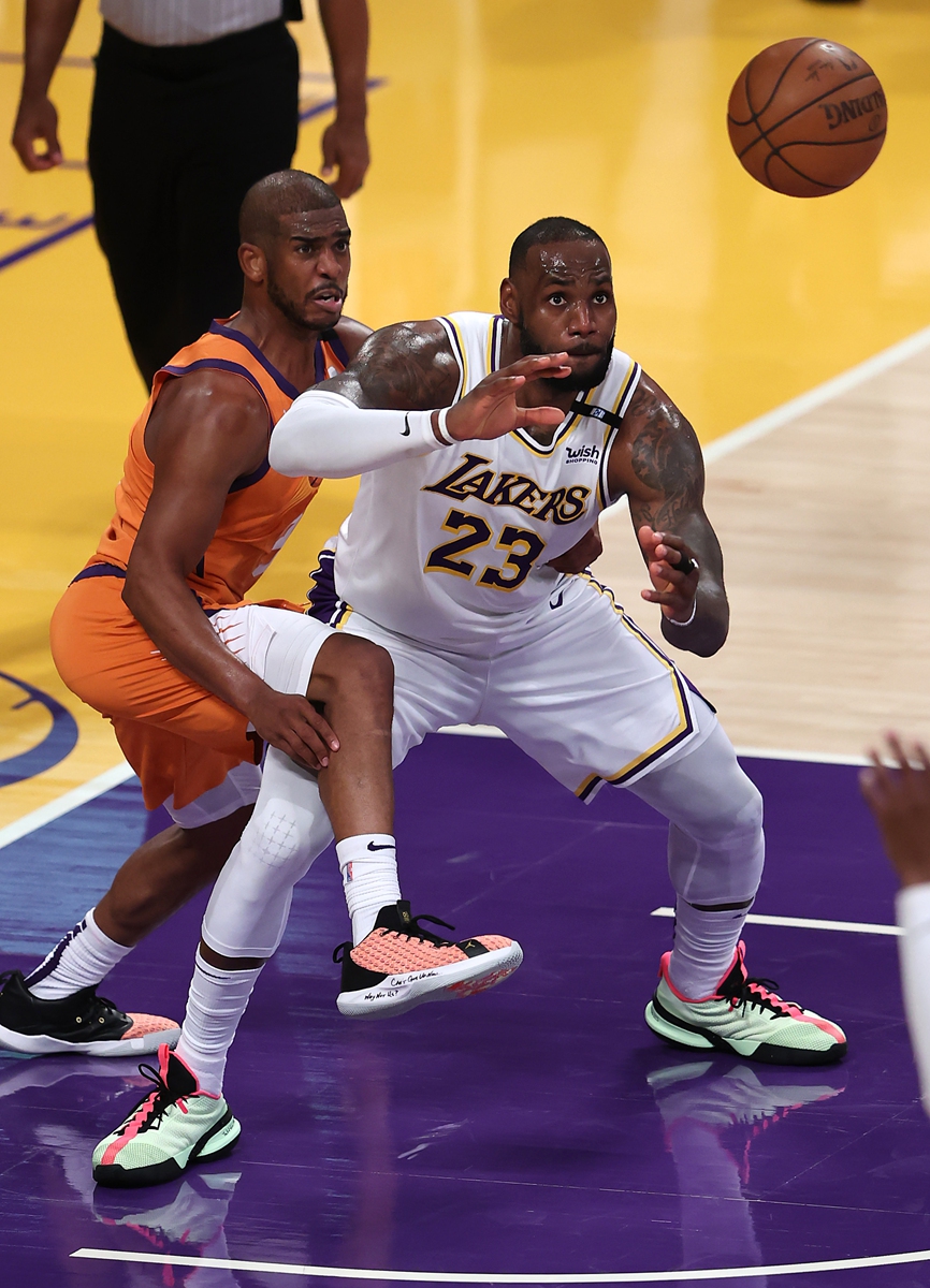 Chris Paul (left) of the Phoenix Suns defends against a pass to LeBron James of the Los Angeles Lakers on Sunday in Los Angeles, California. Photo: VCG