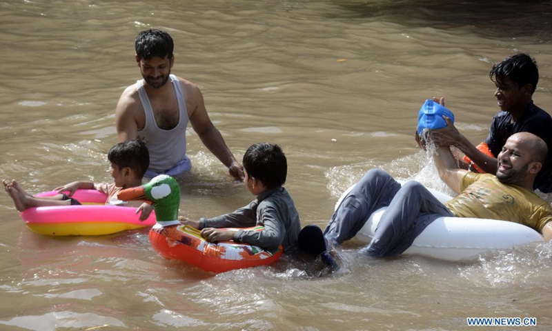 People cool themselves in a canal in Lahore, capital of Pakistan's Punjab province, on May 30, 2021. The temperature reached 38 degrees Celsius in Lahore on Sunday, according to the Pakistan Meteorological Department.(Photo: Xinhua)