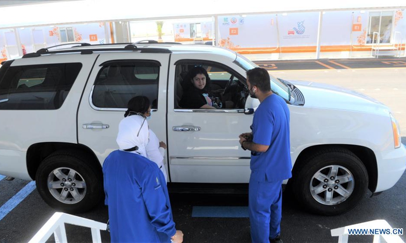 Medical workers talk to a woman inside a vehicle at a drive-through vaccination center in Kuwait City, Kuwait, on May 30, 2021. Kuwait inaugurated on Sunday the drive-through vaccination center to speed up nationwide inoculation.(Photo: Xinhua)