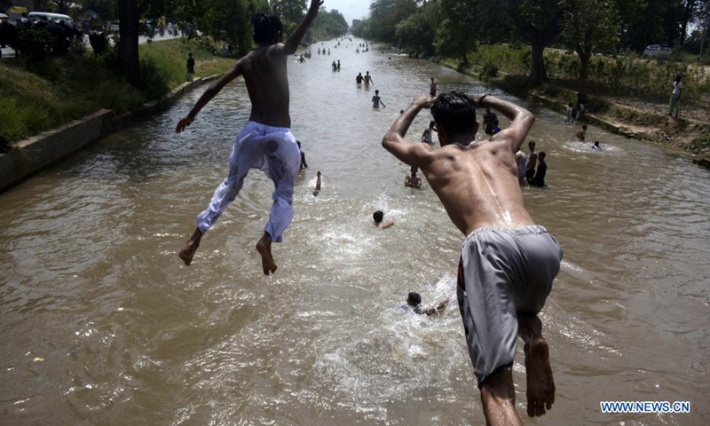 Men jump into a canal to cool themselves in Lahore, capital of Pakistan's Punjab province, on May 30, 2021. The temperature reached 38 degrees Celsius in Lahore on Sunday, according to the Pakistan Meteorological Department.(Photo: Xinhua)