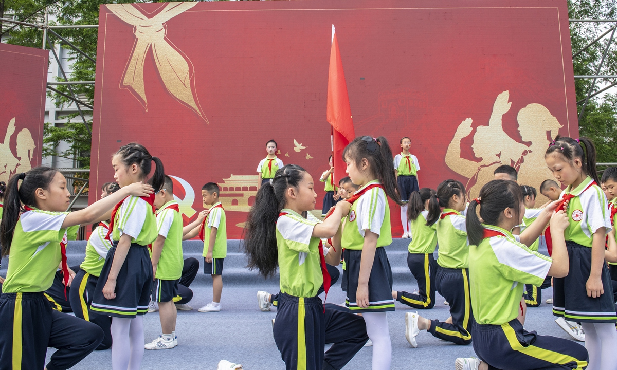 Students in a primary school in Langzhong, Southwest China's Sichuan Province wear red scarves as fresh members of Young Pioneers on Monday, a day ahead of the International Children's Day. The red scarf is the emblem of the Young Pioneers,  a state-run organization of 130 million children under the leadership of the Communist Party of China. Photo: VCG