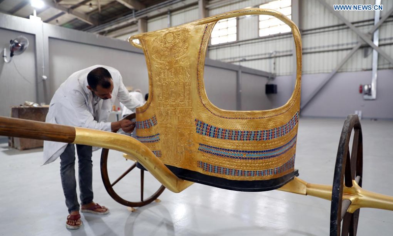 A man works on a replica of Tutankhamun's chariot at Konouz Egypt Replica Treasures in Qalyubia, Egypt, on May 25, 2021. Dozens of designers, sculptors, painters and workers, were busy producing replicas of ancient Egyptian artifacts at Konouz Egypt Replica Treasures, the first factory in Egypt and the Middle East for producing replicas of historical Egyptian antiquities.Photo:Xinhua 