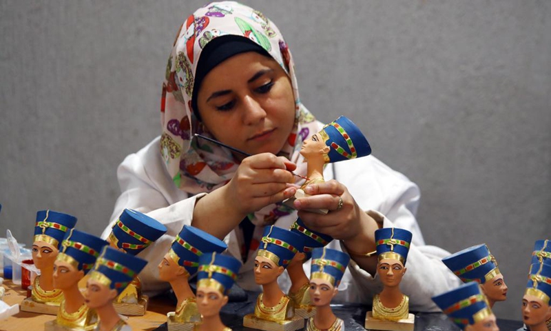 A painter colors a replica of ancient Egyptian Queen Nefertiti's bust at Konouz Egypt Replica Treasures in Qalyubia, Egypt, on May 25, 2021. Dozens of designers, sculptors, painters and workers, were busy producing replicas of ancient Egyptian artifacts at Konouz Egypt Replica Treasures, the first factory in Egypt and the Middle East for producing replicas of historical Egyptian antiquities.Photo: Xinhua


