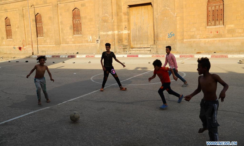 Children play football on an open space at a slum area with cemeteries, in Cairo, Egypt, June 1, 2021. Children living in the slum enjoy themselves by playing football on a simply-equipped football field on Tuesday that marks the International Children's Day(Photo: Xinhua)