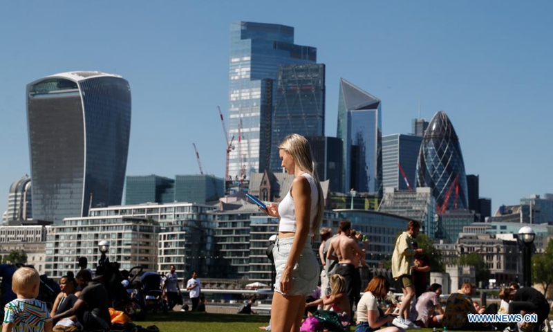 People enjoy sunshine, backdropped by the City of London buildings in London, Britain, June 1, 2021. Britain remains in a vulnerable position in fighting coronavirus despite the progress of the country's vaccination program, a scientist advising the British government said Tuesday. Professor Adam Finn from the Joint Committee on Vaccination and Immunisation, which advises the government on vaccine priority, said the job to contain the pandemic is not done as large numbers of people are still unvaccinated.(Photo: Xinhua)