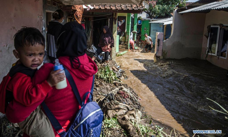 People walk on a muddy road after a flood in Bandung, West Java, Indonesia, June 2, 2021.(Photo: Xinhua)