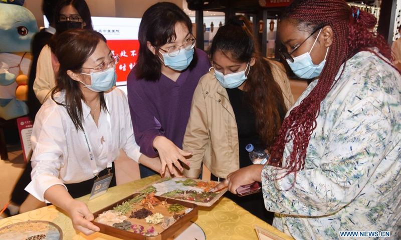 International students learn to recognize Chinese medicinal herbs at the 2nd Global Health Expo of Boao Forum for Asia in Qingdao, east China's Shandong Province, June 1, 2021.(Photo: Xinhua)