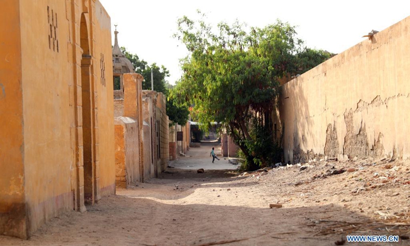 A child plays football on an open space at a slum area with cemeteries, in Cairo, Egypt, June 1, 2021. Children living in the slum enjoy themselves by playing football on a simply-equipped football field on Tuesday that marks the International Children's Day.(Photo: Xinhua)