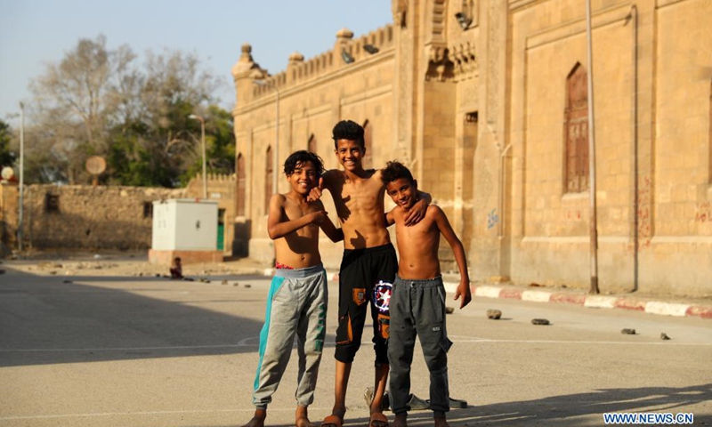 Children pose for a photo while playing football on an open space at a slum area with cemeteries, in Cairo, Egypt, June 1, 2021. Children living in the slum enjoy themselves by playing football on a simply-equipped football field on Tuesday that marks the International Children's Day.(Photo: Xinhua)