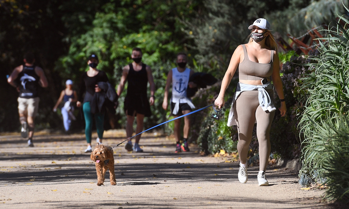 People exercise in Melbourne, Australia on Wednesday with the coronavirus lockdown of the country's second-biggest city to be extended by another seven days, authorities announced as they attempt to stamp out a cluster of cases in the city. Photo: AFP
