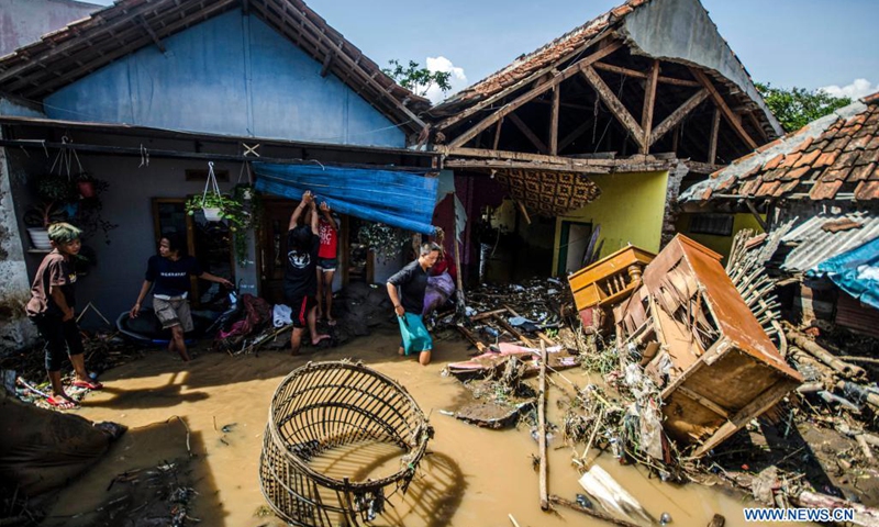People walk through floodwaters after a flood in Bandung, West Java, Indonesia, June 2, 2021.(Photo: Xinhua)