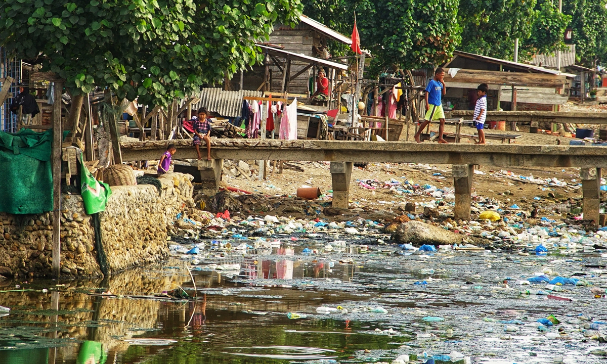 Children play by a river mouth that has been inundated with rubbish at a coastal village in Lhokseumawe, Indonesia's Aceh Province on Thursday.  Research by the University of Georgia, the US, which was published in 2018, said that Indonesia's oceans are the places to find the second largest plastic waste in the world. Photo: AFP