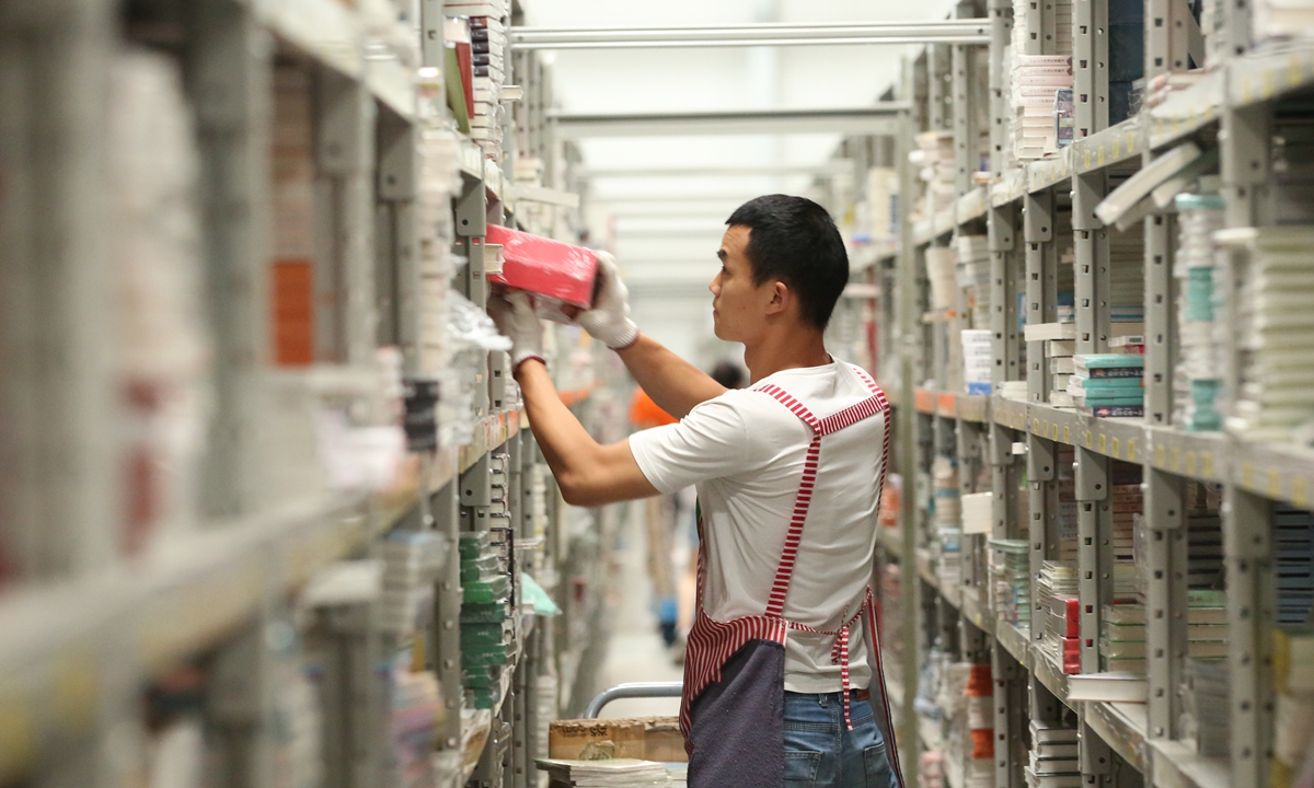 An employee packs products at a warehouse of e-commerce platform dangdang.com in Meishan, Southwest China's Sichuan Province on Thursday. As the June 18 shopping festival nears, employees are working extra hours to cope with the orders. Photo: cnsphotos