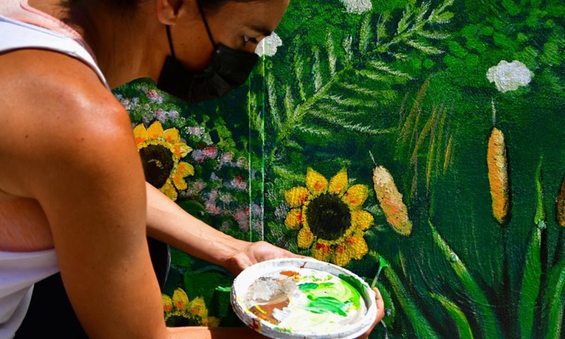 Artist Nathalie Micallef adds the finishing touches to a mural at the Peace Garden in Gharghur, Malta, June 3, 2021. Micallef has spent all her free time since January turning blank walls here into vibrant visuals. Photo: Xinhua