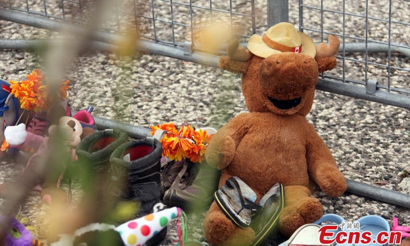 Children’s shoes, dolls, flowers with notes at the front of Legislative Assembly of Ontario, Toronto, Ontario, Canada, June 2, 2021.Photo:China News Service