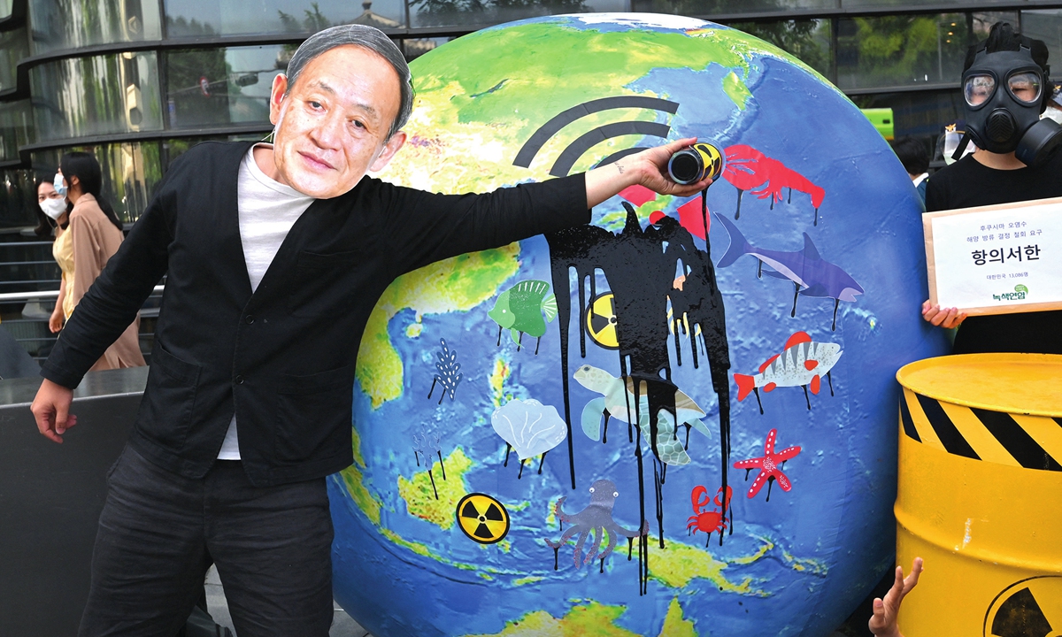 A South Korean environmental activist wearing a mask of Japan's Prime Minister Yoshihide Suga performs during a protest against Japan's decision to discharge Fukushima wastewater into the sea, near the Japanese embassy in Seoul on Friday. Photo: AFP