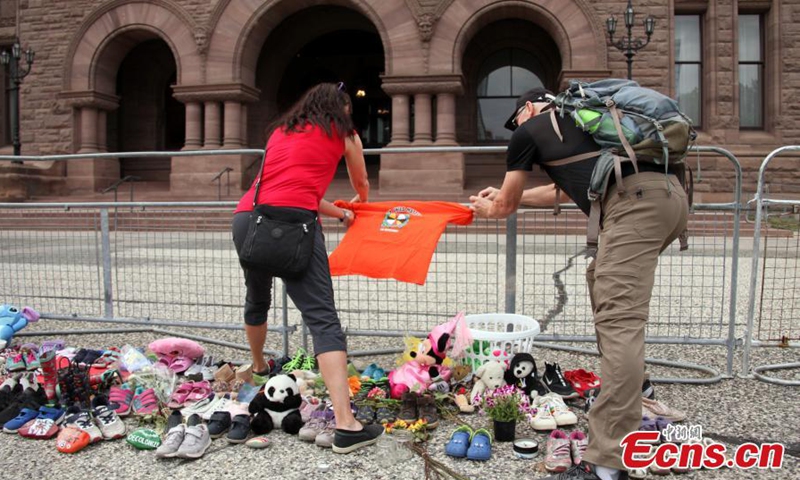 An orange shirt printed with the message “Every Child Matters” is tied to an iron fence at the front of Legislative Assembly of Ontario, Toronto, Ontario, Canada, June 2, 2021.Photo:China News Service